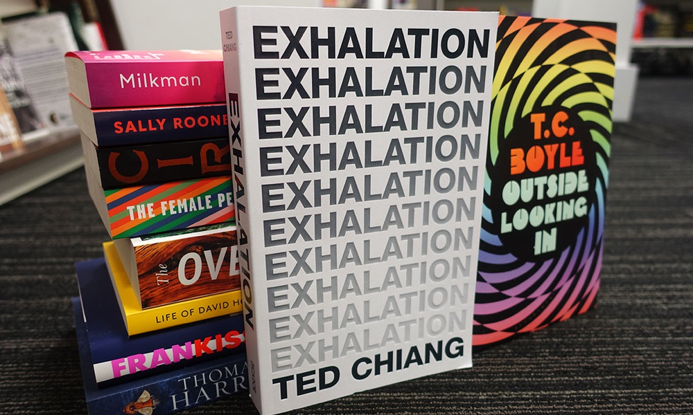 A stack of books with Ted Chain's Exhalation and TC Boyle's Outside Looking In in prime place.